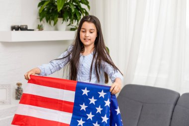 Tatlı küçük kız ve arka planda Amerikan bayrağı.