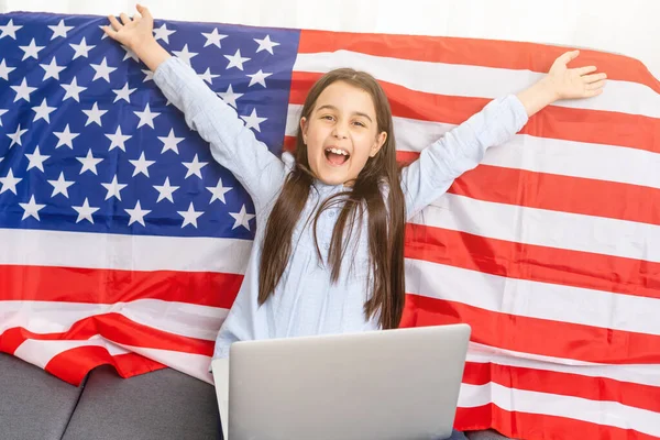 다시 온라인 학교 교육으로 돌아가 봅시다. 영어를 사용하기 어렵다. 아이들은 컴퓨터로 숙제를 합니다. 미국 국기때문에 노트북으로 공부하는 학생들. 멀리 서 가르치는 투덜. — 스톡 사진
