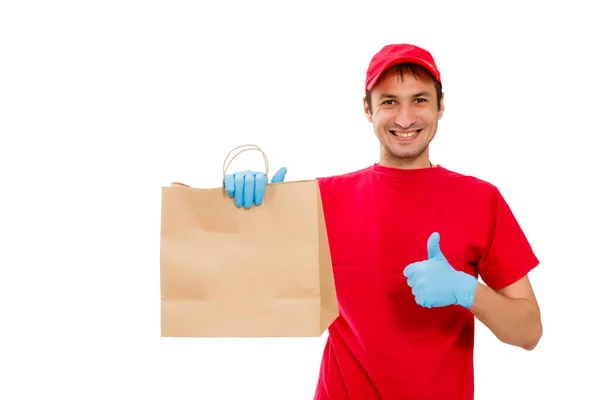 Conceito coronavírus - retrato do homem de entrega em máscara protetora e luvas de proteção segurando saco de papel com comida sobre fundo branco — Fotografia de Stock