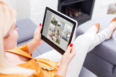 Modern bir evde ev yapımı 3D bir ev otomasyon kontrol istasyonuna sahip bir kadın.