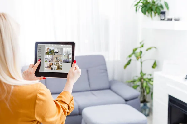 Young woman sitting at modern home using smart home station. — Stock Photo, Image