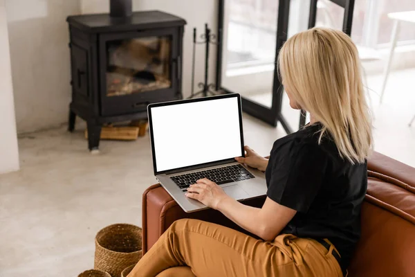 Portret van een vrouw van middelbare leeftijd met behulp van haar lege scherm laptop terwijl achterover leunen op de bank thuis. — Stockfoto