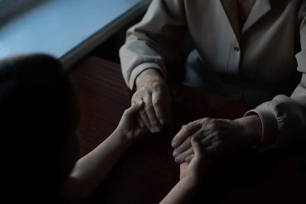 Zeer oude vrouw die de handen van een kind vasthoudt — Stockfoto