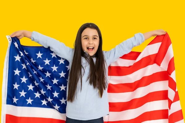 Amerika Birleşik Devletleri bayraklı mutlu kız çocuğu. Sarı arka planda ABD. — Stok fotoğraf
