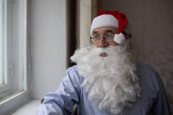 Portrait d'un homme âgé en chapeau de Père Noël regardant la caméra — Photo