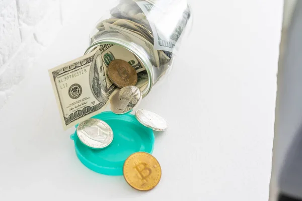 Εξοικονόμηση χρημάτων σε βάζο. Σύμβολο της επένδυσης, διατηρώντας την έννοια του χρήματος. Μαζεύει χαρτονομίσματα σε γυάλινο τενεκεδένιο κουτί. Αμερικανική δολάρια close-up με την αύξηση στήλες των χρυσών νομισμάτων στο τραπέζι — Φωτογραφία Αρχείου