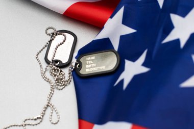 Zincirdeki kimlik kartları, ordu rozeti..