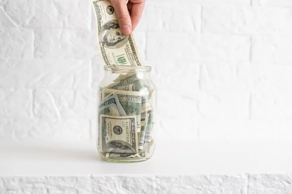 Veel dollars bankbiljetten in een glazen pot geïsoleerd op witte achtergrond — Stockfoto