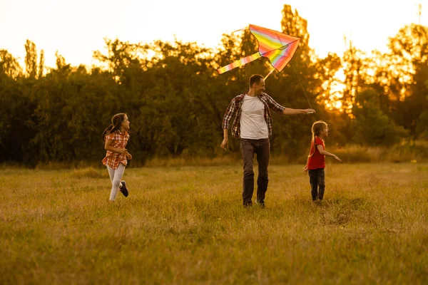 Pai com sua filhinha deixou um papagaio em um campo — Fotografia de Stock