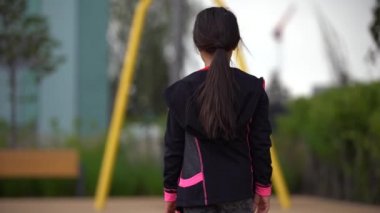 Çocuk parkında oynayan küçük kız. Mutlu çocuk oyun parkına tırmanıyor, salıncak ve bungee sürüyor, aktif bir yaşam tarzı.