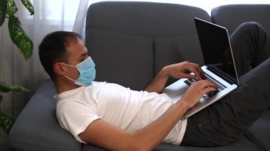 Hasta portresi, tıbbi maske takmış virüslü adam ölüyor. Yatakta yatıyor ve öksürüyor. 