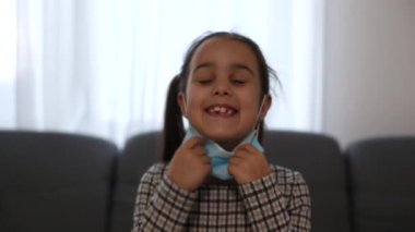 Virüse karşı maske takan hasta küçük bir kız kamera koronavirüsüne yakın çekim yapıyor.