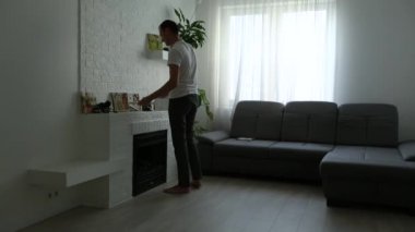 Adam beyaz bir duvara tuval resmi asıyor. Yaratıcı atölye