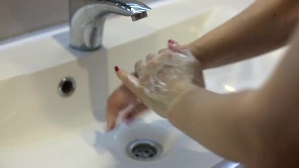 Vista de cerca de una mujer lavándose las manos en el baño. Una mujer se lava las manos en el lavabo. — Vídeos de Stock