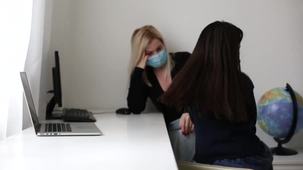 Educación a distancia en línea. Enfermera colegiala en máscara médica estudiando en casa con el ordenador portátil y haciendo la tarea de la escuela. — Vídeo de stock