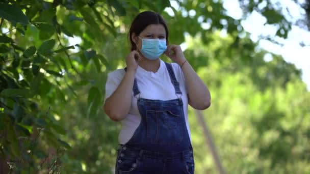 Νεαρή έγκυος γυναίκα που περπατά στη φύση και φοράει μάσκα προσώπου ασφαλείας σε πανδημίες — Αρχείο Βίντεο