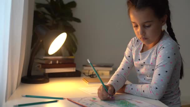 Nettes intelligentes Grundschulmädchen, das Schreiben lernt, Mathe-Hausaufgaben macht, sitzt zu Hause am Tisch, entzückendes hübsches kleines Vorschulkind, das allein Notizen macht, Kinder Grundschulkonzept — Stockvideo