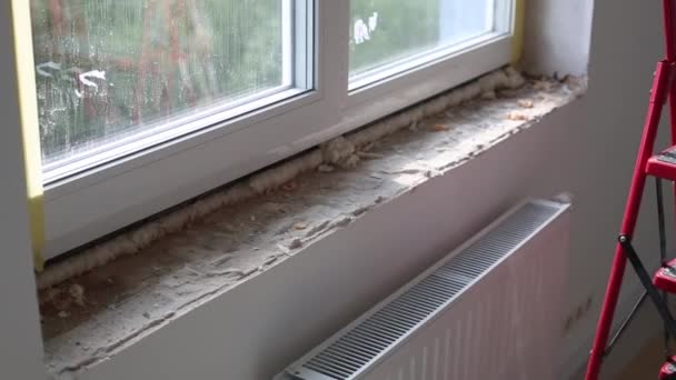 Reparatie in de hellingen van het raam. Het aanbrengen van een laag gips aan de zijkanten van het raam. — Stockvideo