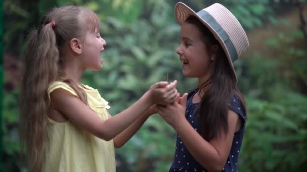 Children hands and flying butterfly against green spring background. Ecology concept — Stock Video