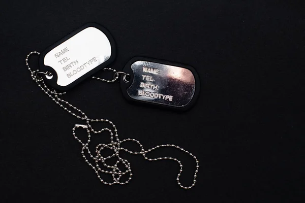Étiquette de chien, chaînes de l'armée, badge de l'armée sur le fond sombre. — Photo