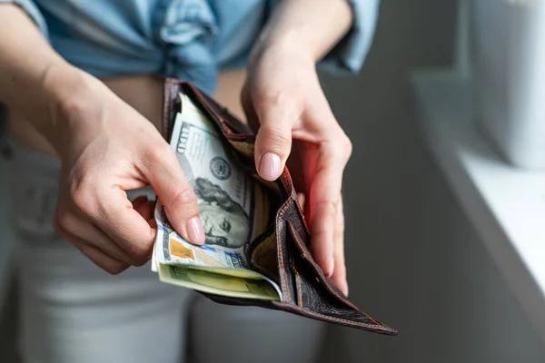 Mulher colocando notas de dólar em sua bolsa — Fotografia de Stock