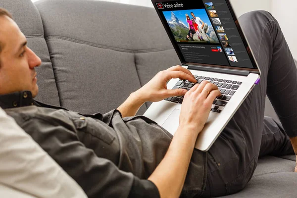 Hombre que busca información para planificar el viaje futuro, hacer la reserva de hotel en el sitio web utilizando Internet en el interior, un hombre viendo un video sobre un viaje en línea en un ordenador portátil — Foto de Stock