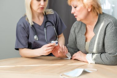 Sıhhiye ve hasta parmak nabız oksimetresi kullanıyor