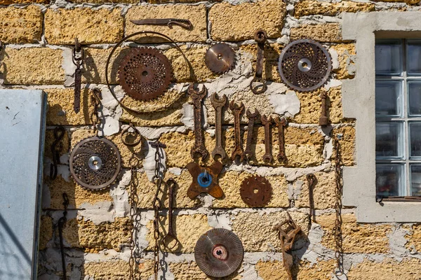 Viejas herramientas sucias del jardín del metal de la granja como palas y rastrillos que cuelgan en la pared en clavos — Foto de Stock