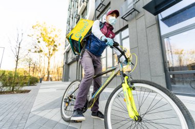 KIEV, UKRAINE - 28 Nisan 2021: Glovo bisikletli kurye. Glovo dağıtım servisinin teslimatçısı.