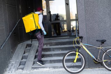 Sarı sırt çantalı teslimatçı.