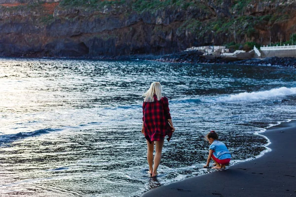 スペインのテネリフェ島で家族の休日。海の上で娘と母。肖像旅行の観光客-娘とお母さん。積極的な人間の感情、積極的なライフスタイル。海のビーチで幸せな若い家族 — ストック写真