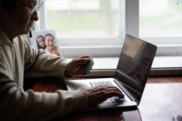 Uomo anziano con gli occhiali utilizzando il computer portatile a casa — Foto Stock