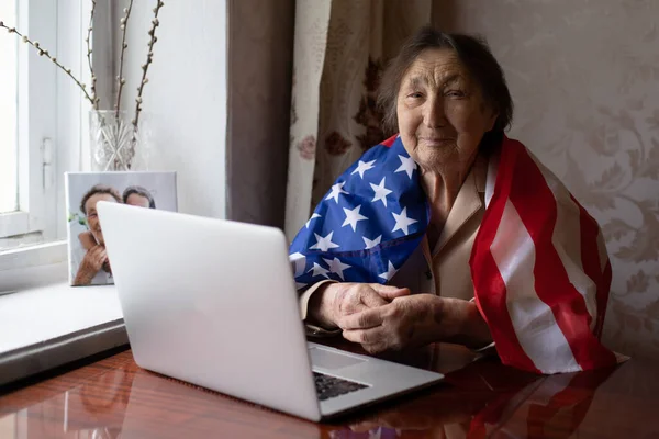 Senior woman with American flag sitting at home — Stock Photo, Image