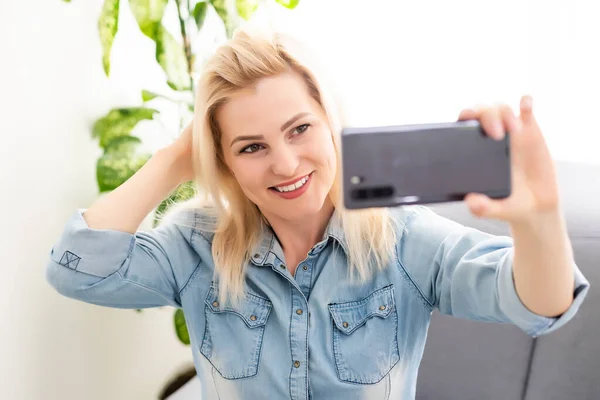 Leende ung kvinna bloggare vlogger influencer arbetar hemma. Flicka talar tittar på kameran talar gör videochatt eller konferenssamtal, Kvinnliga rekord blogg vlog. — Stockfoto