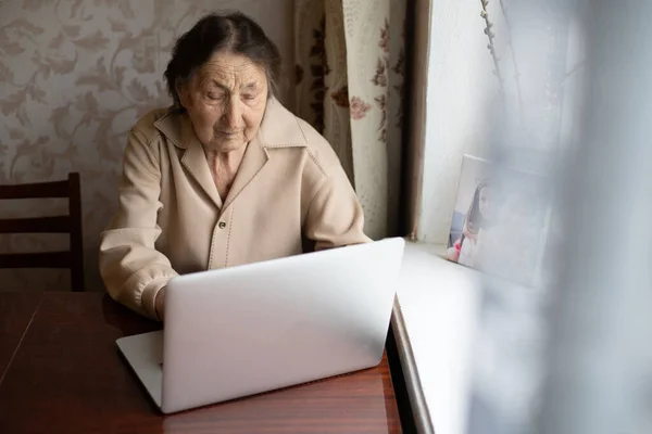 Mulher muito velha usando laptop sentado em casa — Fotografia de Stock