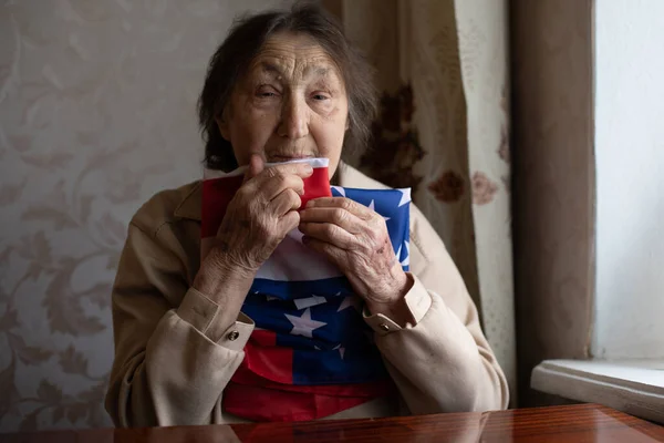 Senior woman with American flag sitting at home — Stock Photo, Image