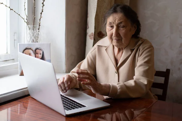 Molto anziana donna felicemente in possesso di un computer portatile — Foto Stock