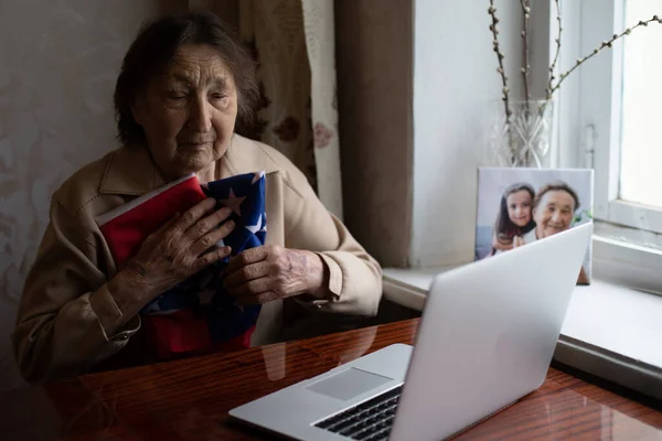 День незалежності після карантину. Бабуся дивиться на екран ноутбука і святкує національне свято з сім'єю онлайн, піклується про старших людей, особисті технології, зосереджується на жінці — стокове фото