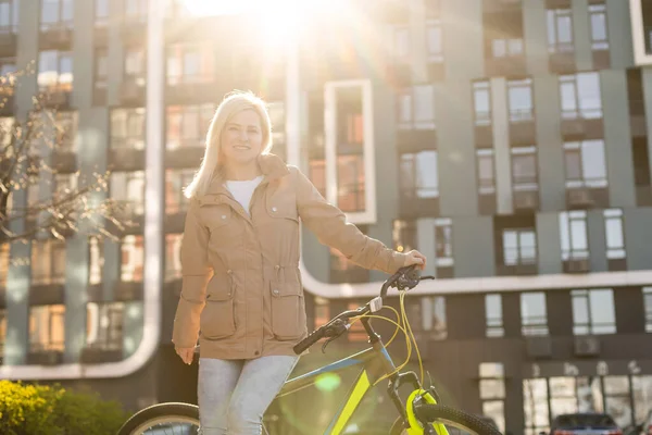 Mulher adulta com bicicleta na cidade — Fotografia de Stock