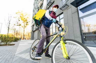 Eve servis için sarı termo çantalı bir teslimatçı. Eve yakın bir yerde. Kopyalamak için boş bir yer var.