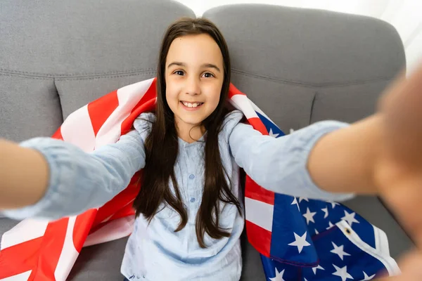一个美丽而快乐的小女孩举着一面美国国旗的照片 — 图库照片