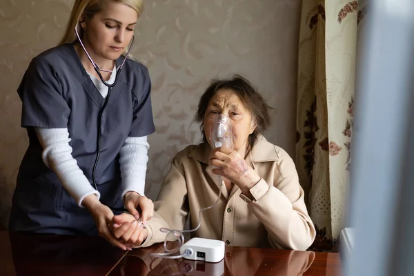 Gentile giovane infermiera che si prende cura di una paziente molto anziana, ospedale — Foto Stock