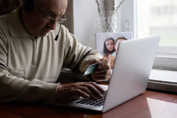 Uomo anziano con gli occhiali utilizzando il computer portatile a casa — Foto Stock