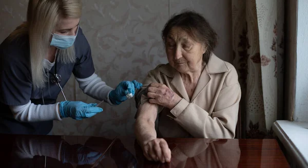 Enfermera que hace la inyección de vacuna al paciente anciano — Foto de Stock