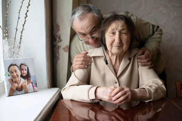 Senior woman gets a kiss from her loving adult son who has come to visit her in the nursing home. — Stock Photo, Image