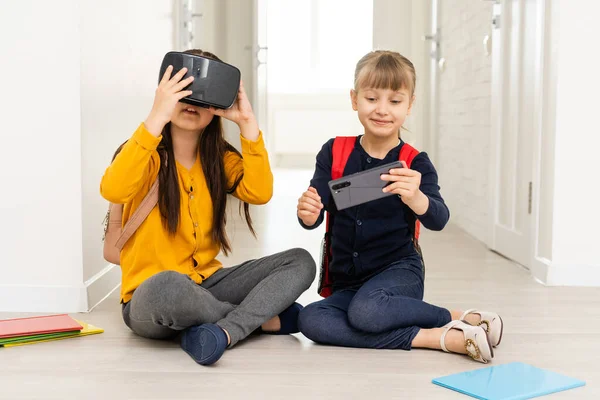 Trying new technologies. Little schoolgirl wearing big VR glasses being impressed playing virtual games at school. — Stock Photo, Image