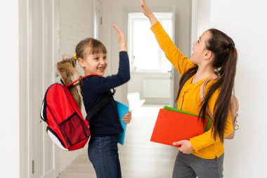 İlkokul kızları sınıf binasında yürüyorlar..