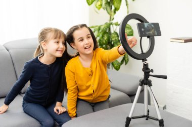 Fotoğrafı kapatın. İki küçük kız selfie çekin, konuşun, konuşun, konuşun.