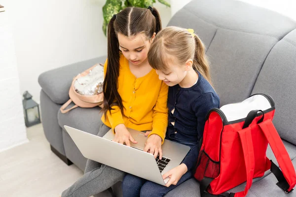 귀여운 두 소녀가 노트북을 가지고 즐겁고 행복하게 놀고 있습니다. — 스톡 사진