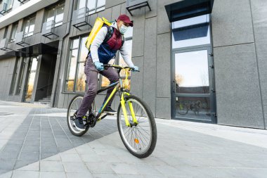 Sarı sırt çantalı teslimatçı.